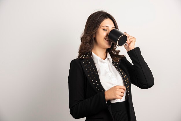 Female worker drinking herbal on white