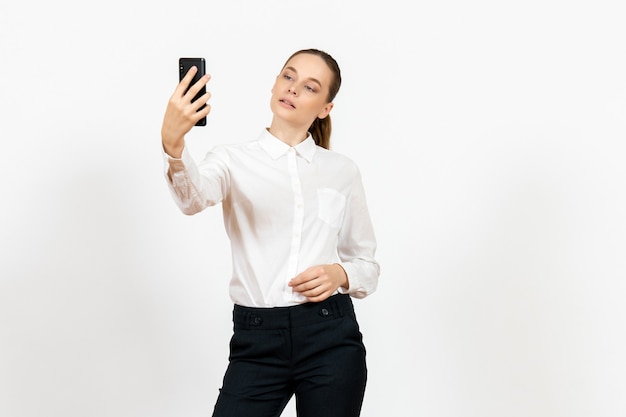female worker in elegant white blouse taking selfie on white
