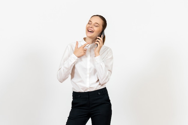 female worker in elegant white blouse talking on phone and laughing on white