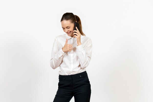 female worker in elegant white blouse talking on phone on white