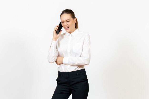 работница в элегантной белой блузке разговаривает по телефону на белом