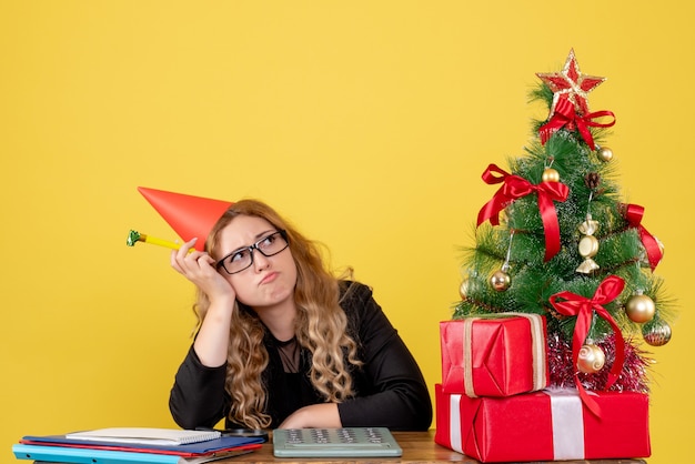 Free photo female worker sittting behind her working place bored on yellow