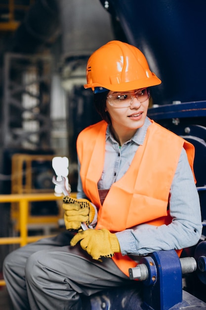 Female worker using wrench at a factory