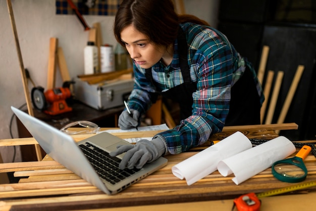 Female working in workshop and using laptop