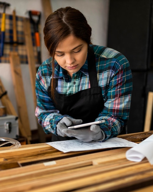 Foto gratuita donna che lavora in officina e utilizza tablet