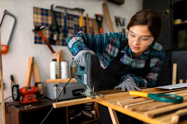 Female working in workshop with hammer drill