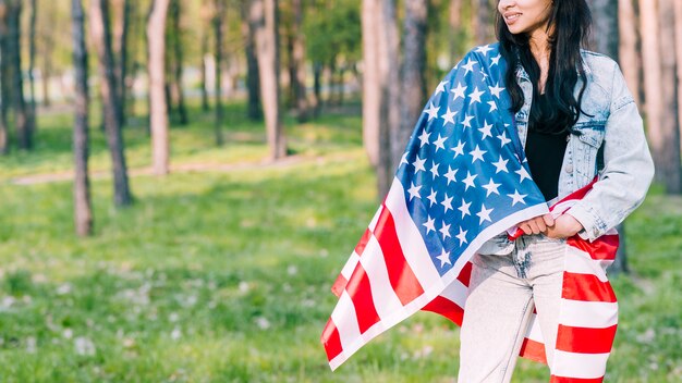 アメリカの国旗を公園で包んだ女性