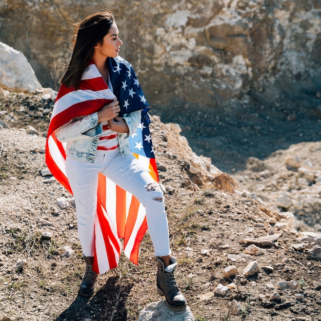 Female wrapped in flag standing on mountain