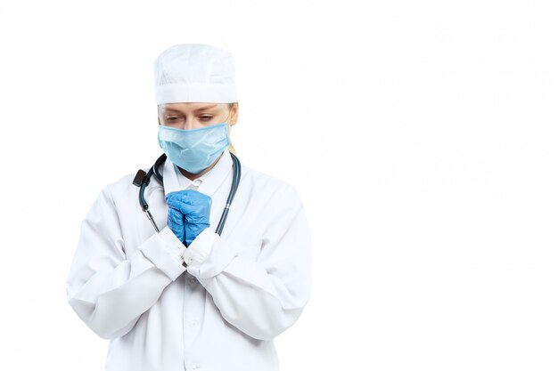 Female young doctor with stethoscope and face mask isolated on white