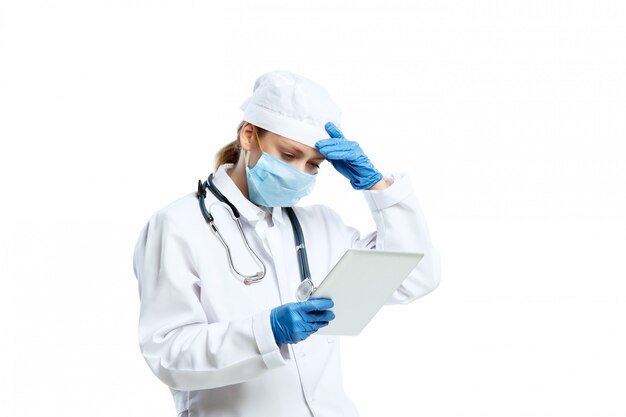 Female young doctor with stethoscope and face mask isolated on white