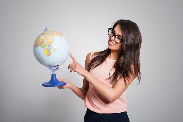 Female young teacher holding globe
