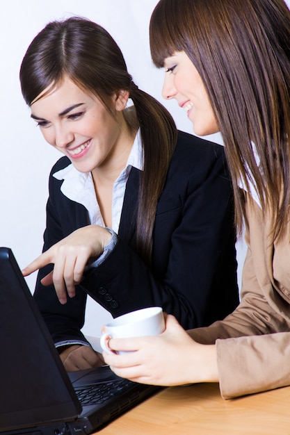 Женщины жестикулируя во время работы на ноутбуке