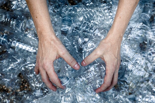 Femals hands grabbing plastic bottles to collect and trash them