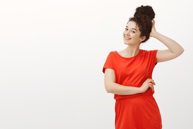 Feminine good-looking adult woman with curly hair combed in bun