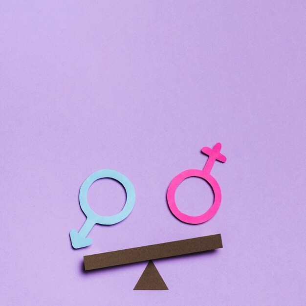 Feminine and masculine gender signs on a seesaw