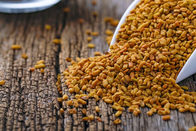 Fenugreek seeds in glass bowl and scoop