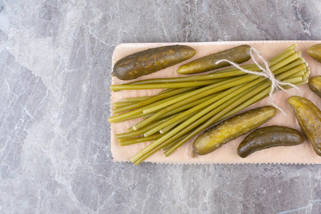 Fermented cucumbers and green beans on wooden board