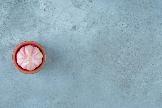 Fermented garlic in a bowl, on the blue table. 