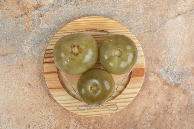 Ферментированные зеленые помидоры на деревянной тарелке