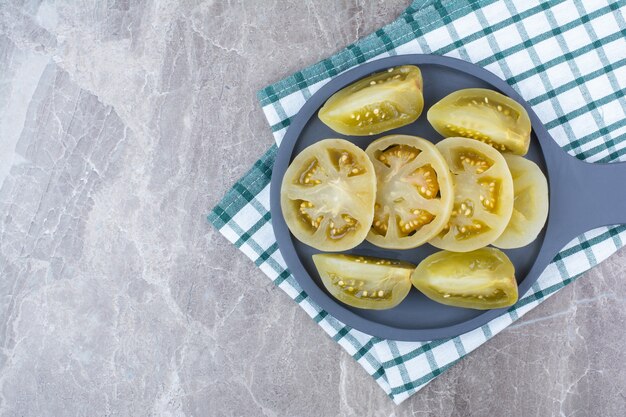 식탁보와 어두운 보드에 발효 토마토 조각.