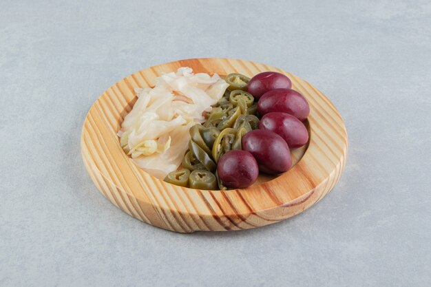 Fermented vegetables placed on wooden plate. 