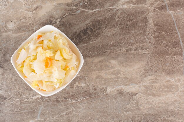 Fermented vegetables sauerkraut placed on stone table.