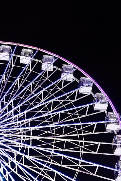 Ferris wheel in blue neon light on a dark background