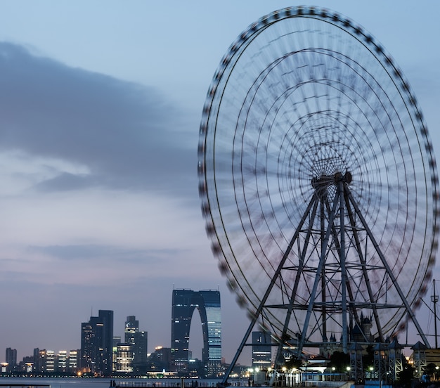 Free photo ferris wheel with cityscape in background