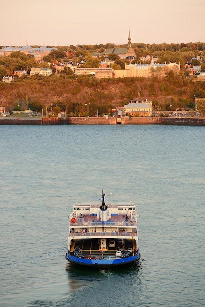 Ferry boat in river in Quebec City at sunset.