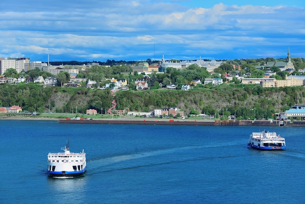 Ferry boat in river in Quebec City with blue sky.
