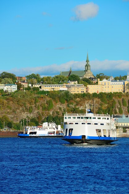 Ferry boat in river in Quebec City with blue sky.