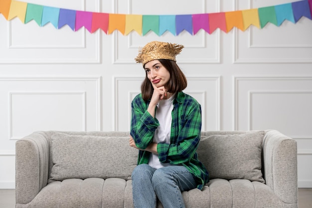 Festa junina adorabile ragazza con cappello di paglia che celebra la festa brasiliana pensando profondamente