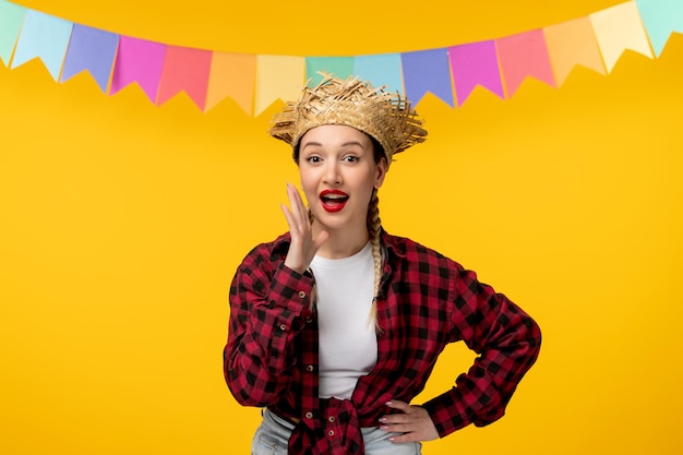 Free photo festa junina blonde cute girl in straw hat brazilian festival with colorful flags calling someone