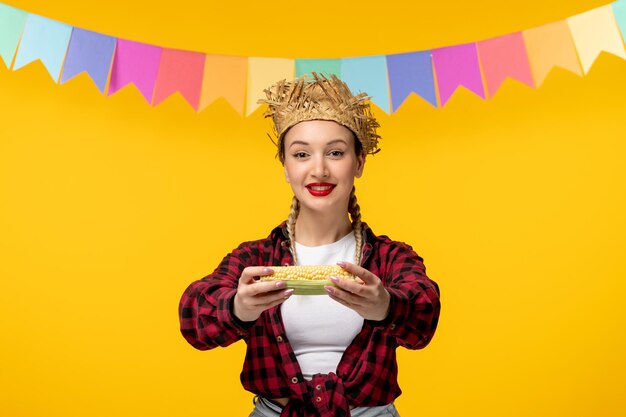 Festa junina blonde cute girl in straw hat brazilian festival with colorful flags giving corn