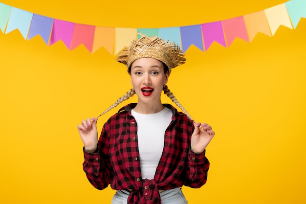 Festa junina 금발 귀여운 소녀 밀짚 모자 브라질 축제 머리 띠를 들고 화려한 깃발