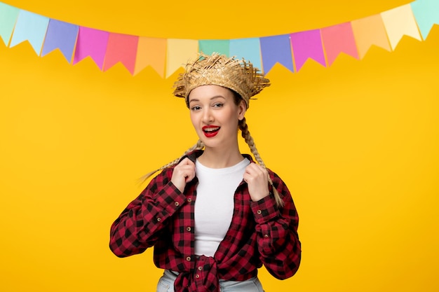 Foto gratuita festa junina bionda ragazza carina in cappello di paglia festival brasiliano con bandiere colorate che tengono il colletto