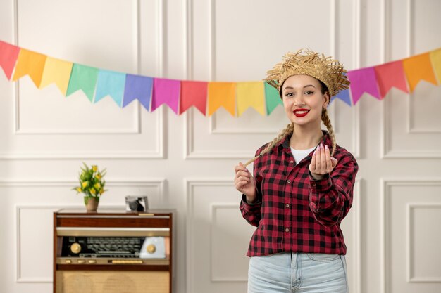 Festa junina cute girl in straw hat brazilian midsummer with retro radio colorful flags smiling