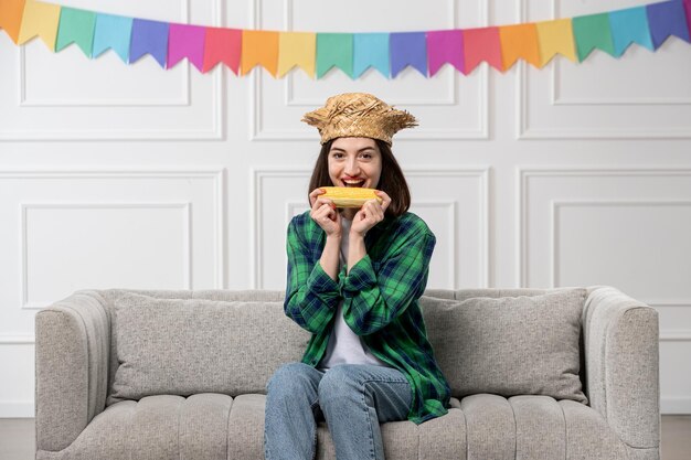 Festa junina happy cute girl with straw hat celebrating brazilian party eating corn