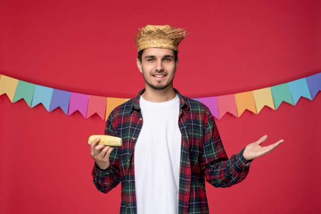 Festa junina happy cute guy wearing straw hat celebrating brazilian festival eating tasty corn