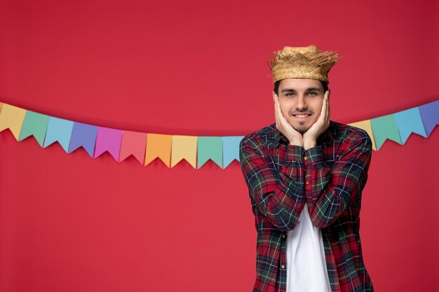 Festa junina happy cute guy wearing straw hat celebrating brazilian festival holding face