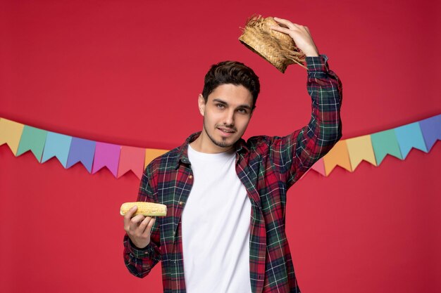 Free photo festa junina happy cute guy wearing straw hat celebrating brazilian festival taking off hat