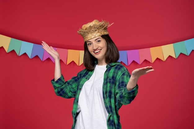 Foto gratuita festa junina bella ragazza carina che indossa un cappello di paglia che celebra il festival brasiliano con bandiera colorata