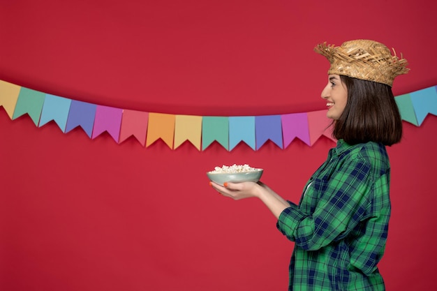 Foto gratuita festa junina in cappello di paglia bruna ragazza carina che celebra il festival brasiliano condividendo il cibo