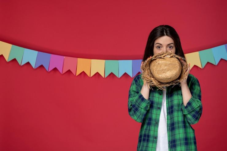 Бесплатный Фотография festa junina молодая милая девушка празднует бразильский фестиваль, закрывая лицо соломенной шляпой