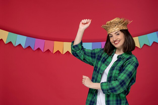 ブラジルのお祭りのダンスを祝う緑のシャツを着たフェスタジュニーナの若いかわいい女の子