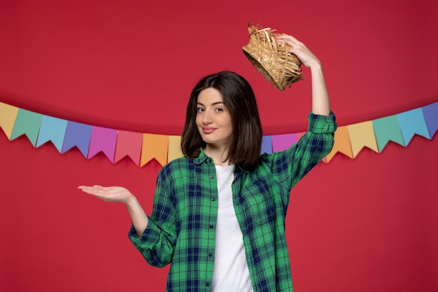 Festa junina giovane ragazza carina in camicia verde che celebra il festival brasiliano togliendosi il cappello di paglia