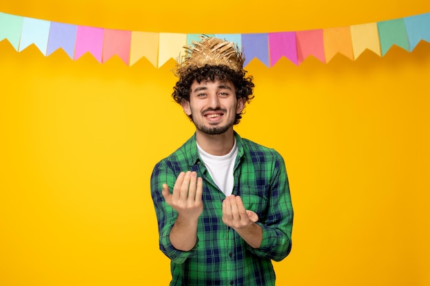 Festa junina 밀짚 모자와 다채로운 깃발 브라질 축제 손으로 초대하는 젊은 귀여운 남자
