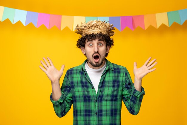 Festa junina young cute guy in straw hat and colorful flags brazilian festival shocked