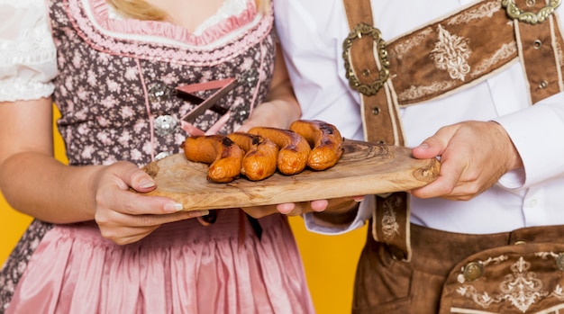 Festival friends holding traditional bratwurst