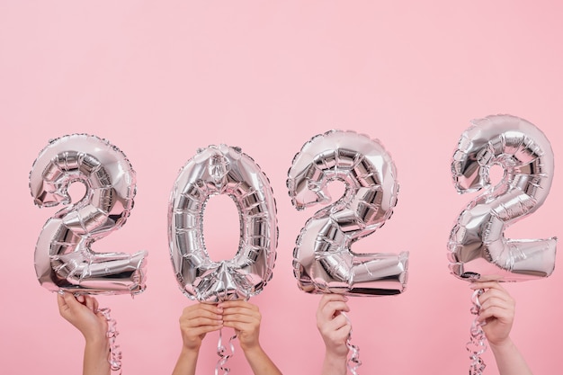 Free photo festive balloons in from the numbers  on a pink background